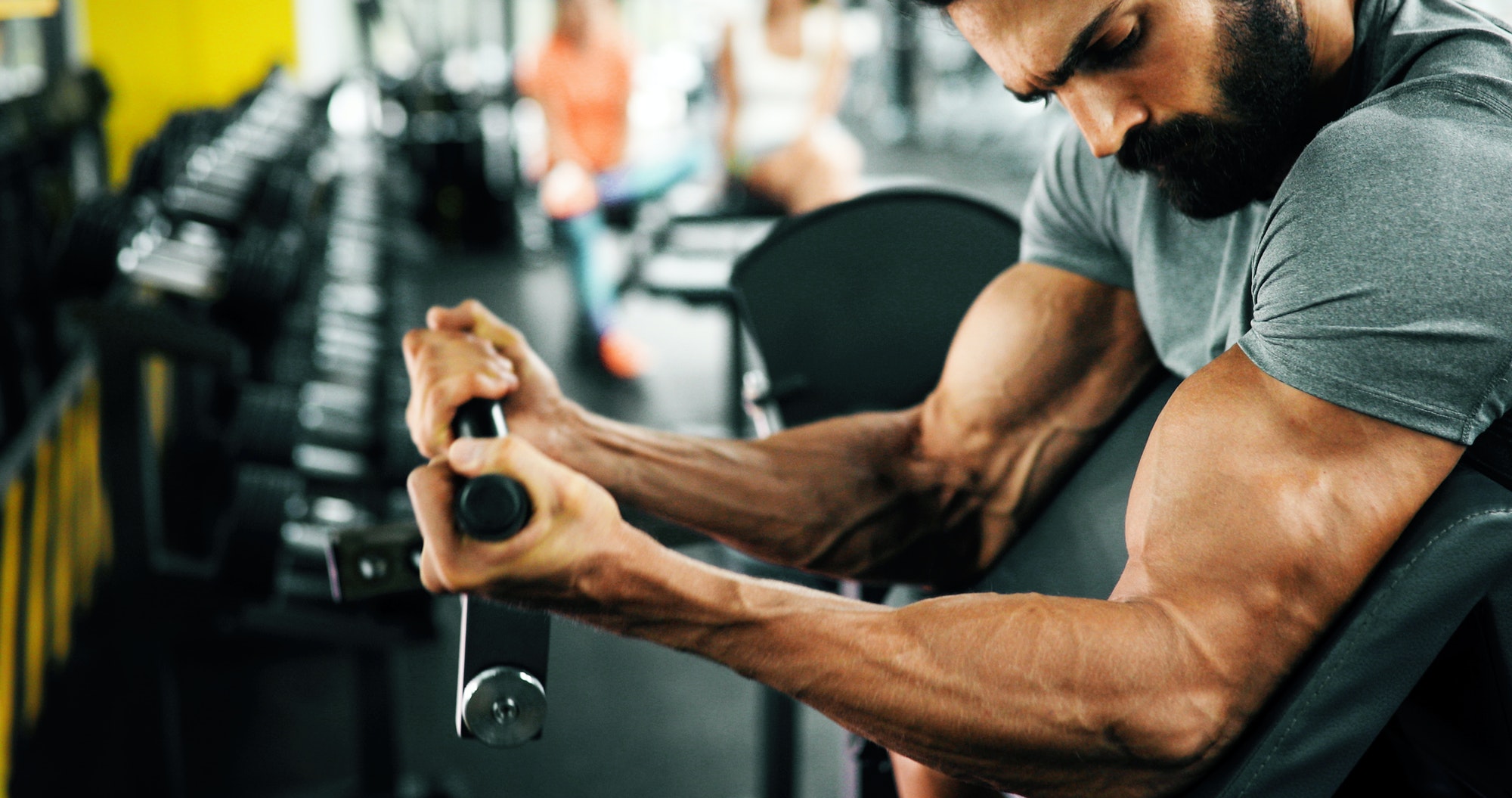 Muscular bodybuilder guy doing exercises in gym