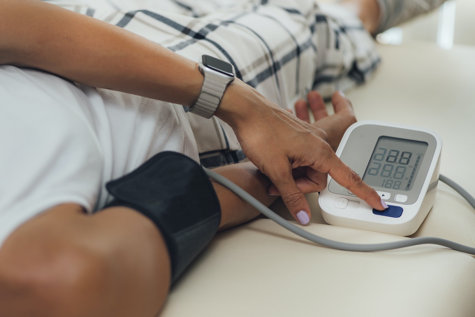 Orthostatic Blood Pressure. Woman Lying on Back and Measuring Blood Pressure on her Arm