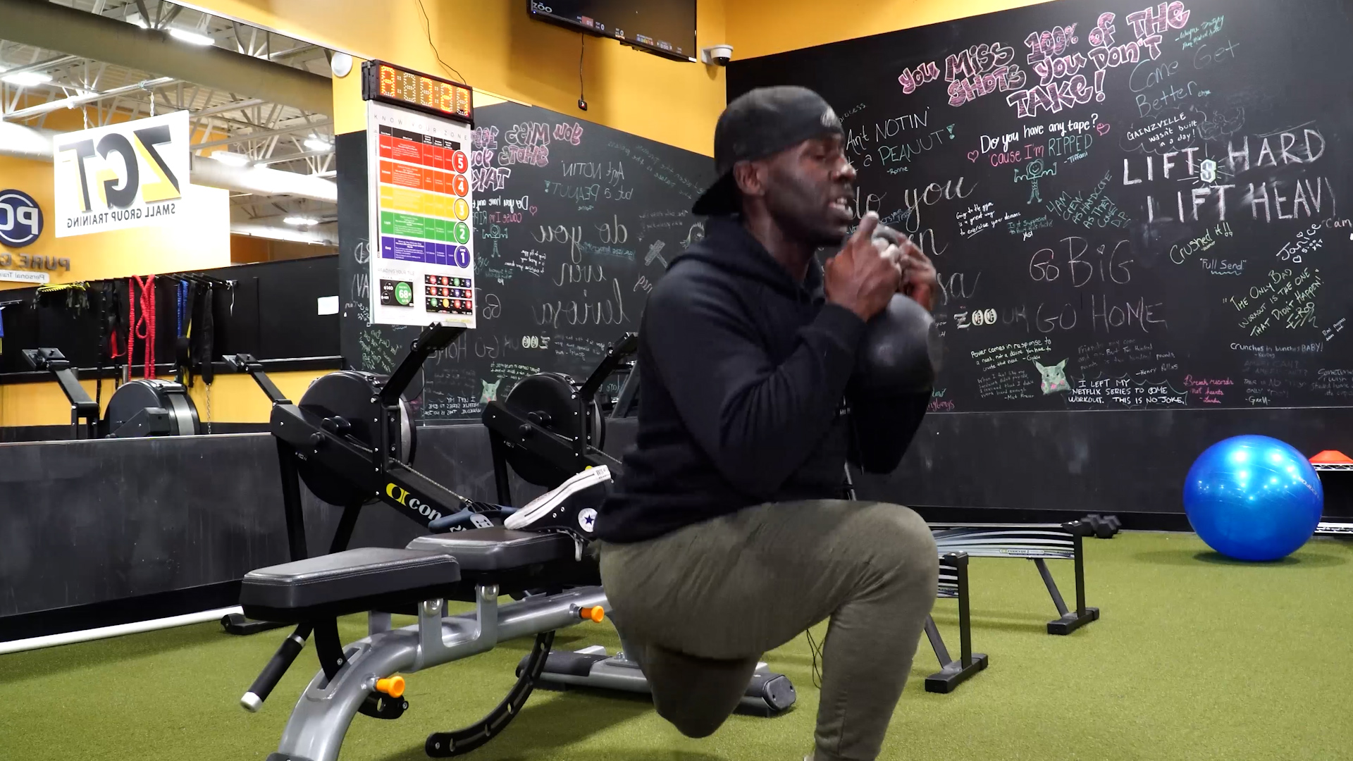 man squats holding kettlebell